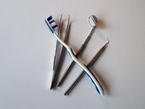 Instrumentación de dentista junto a un cepillo de dientes